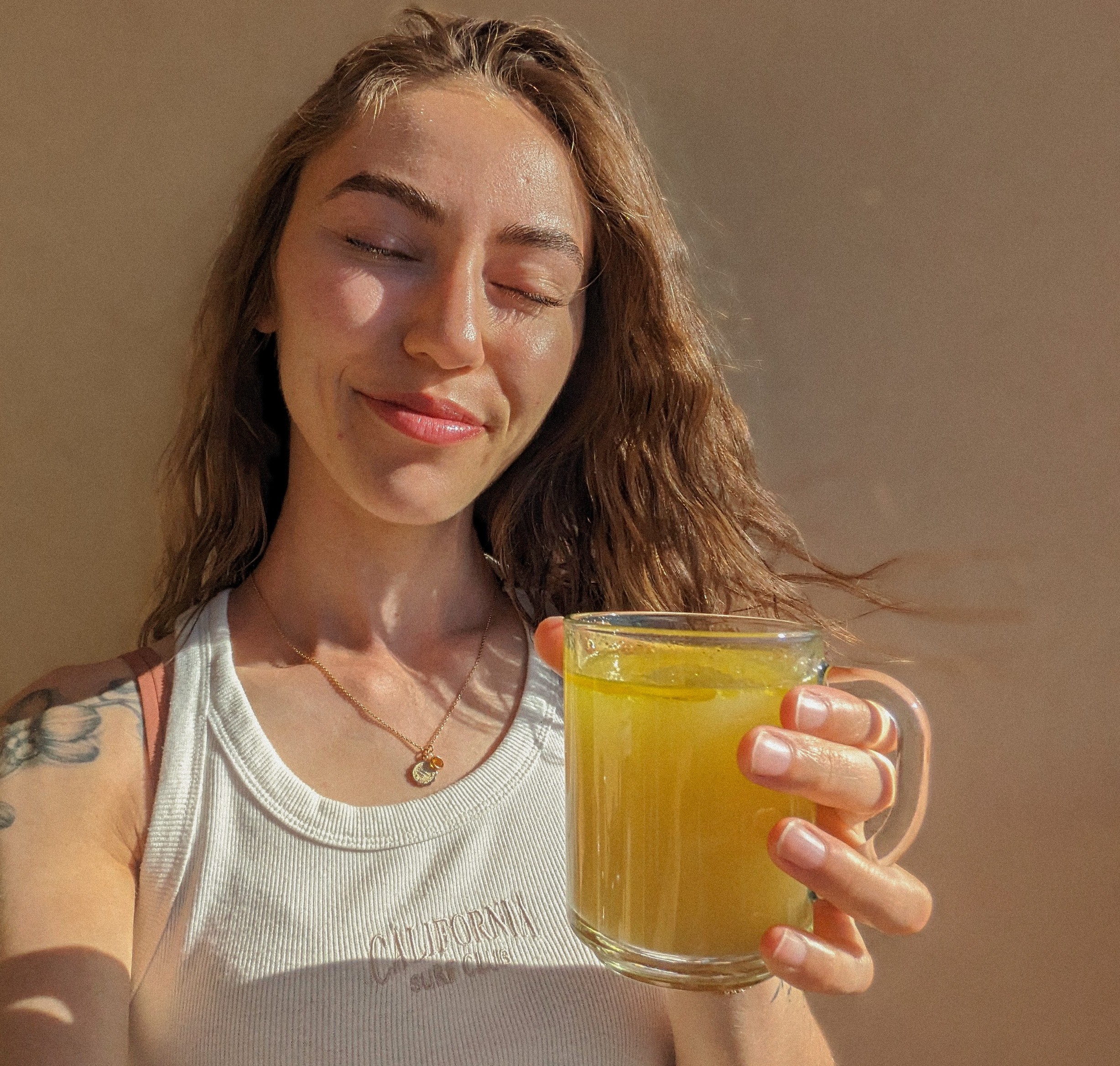 Amy holding a Nettle, Ginger and Turmeric tea beverage