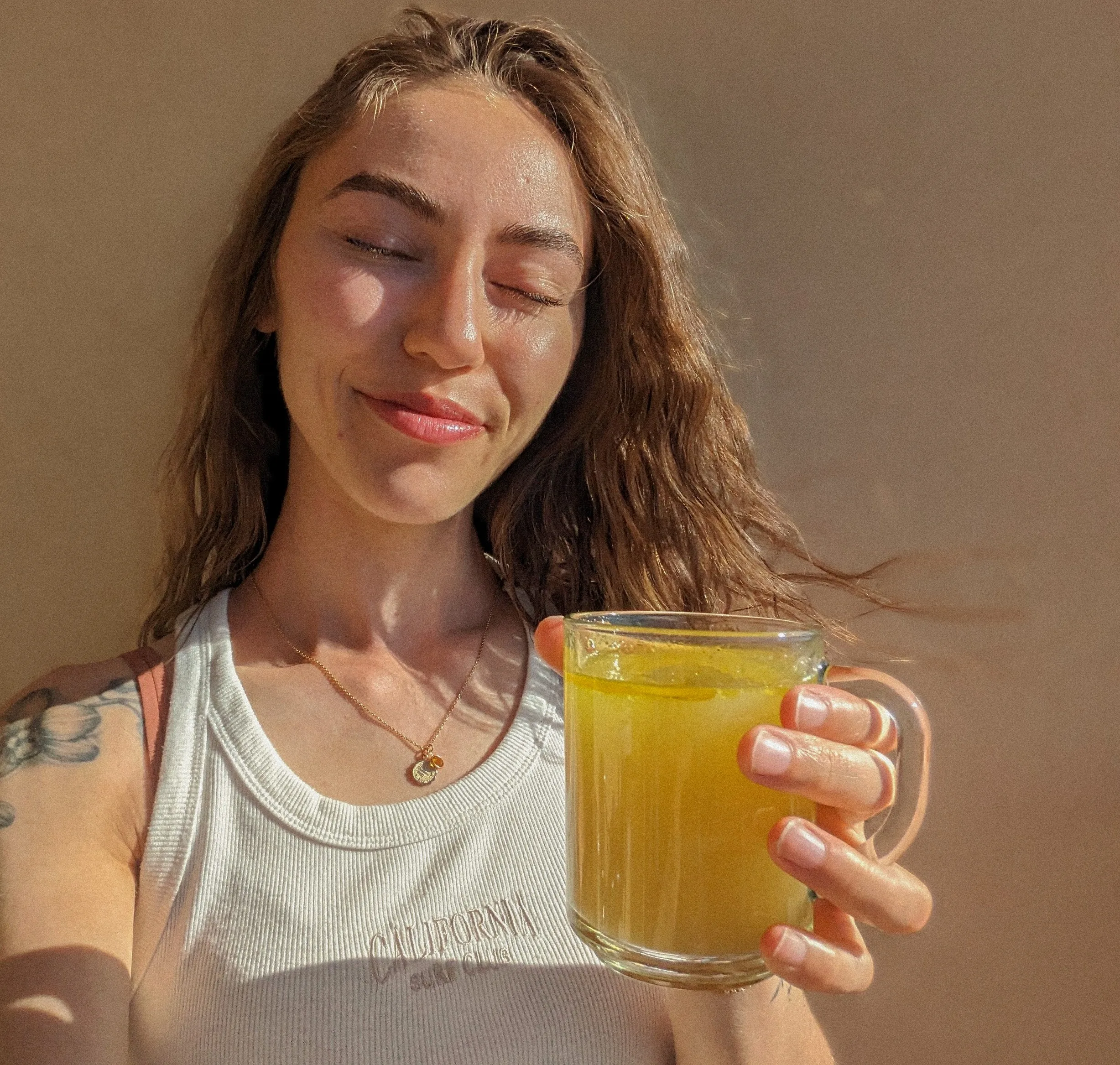 Amy holding a Nettle, Ginger and Turmeric tea beverage
